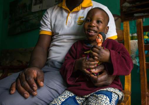 Benin, West Africa, Ouidah, eric and his son paterne with the carved wooden figure made to house the soul of their dead twin paterna