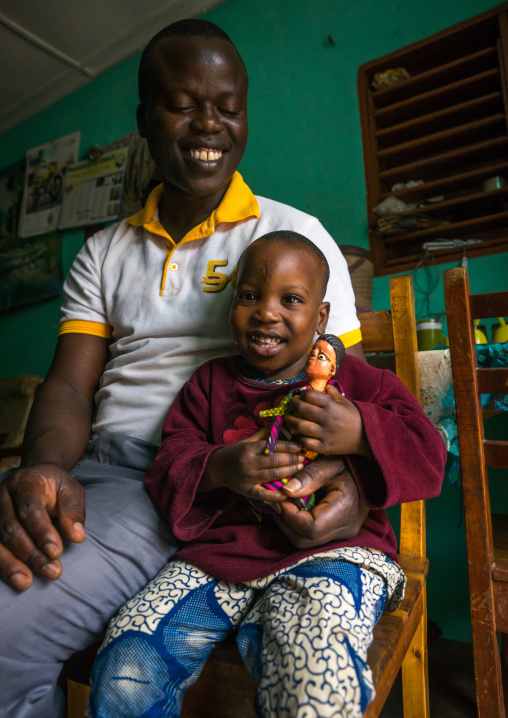 Benin, West Africa, Ouidah, eric and his son paterne with the carved wooden figure made to house the soul of their dead twin paterna