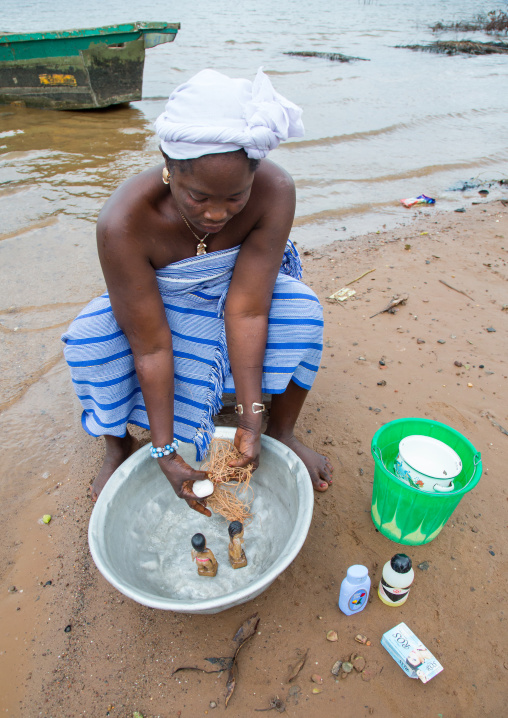 Benin, West Africa, Bopa, miss hounyoga washing the carved wooden figures made to house the soul of her dead twins