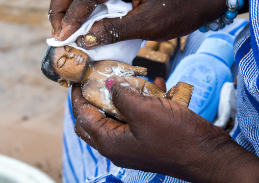 Benin, West Africa, Bopa, miss hounyoga washing the carved wooden figures made to house the soul of her dead twins