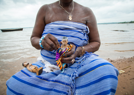 Benin, West Africa, Bopa, miss hounyoga washing the carved wooden figures made to house the soul of her dead twins
