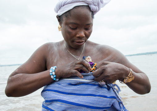 Benin, West Africa, Bopa, miss hounyoga carrying the carved wooden figures made to house the soul of her dead twins