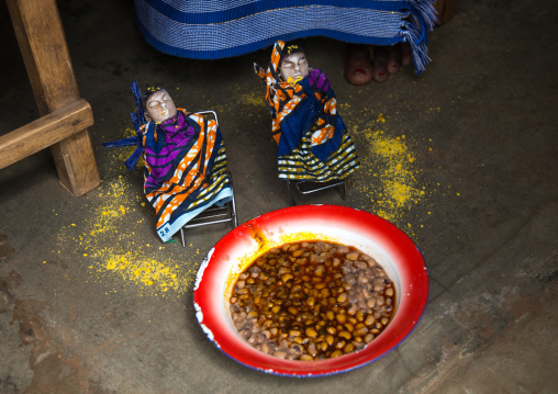 Benin, West Africa, Bopa, miss hounyoga giving beans cooked with oil to the carved wooden figures made to house the soul of her dead twins