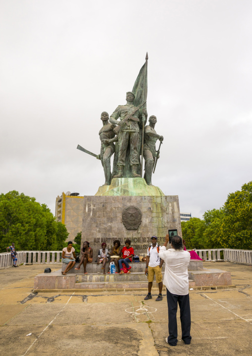 Benin, West Africa, Cotonou, beninese men taking pictures in front of 1977 martyrs monument made by north korean artists
