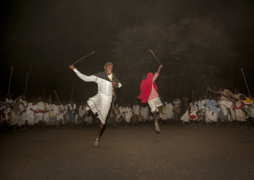 Night Shot Of Two Karrayyu Tribe Men Jumping During A Choreographed Stick Fighting Dance At Gadaaa Ceremony, Metahara, Ethiopia