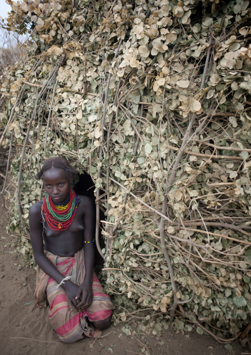 Teenage Dassanech Girl At Entrance Of Natural Materials Hut Omorate Ethiopia