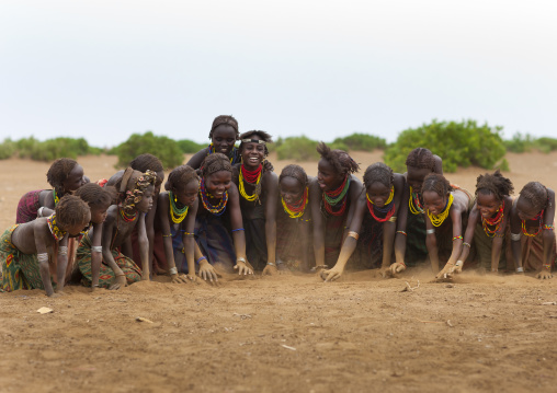 Group Of Dassanech Tribe Youngsters Digging The Sand In A Row Omorate Ethiopia