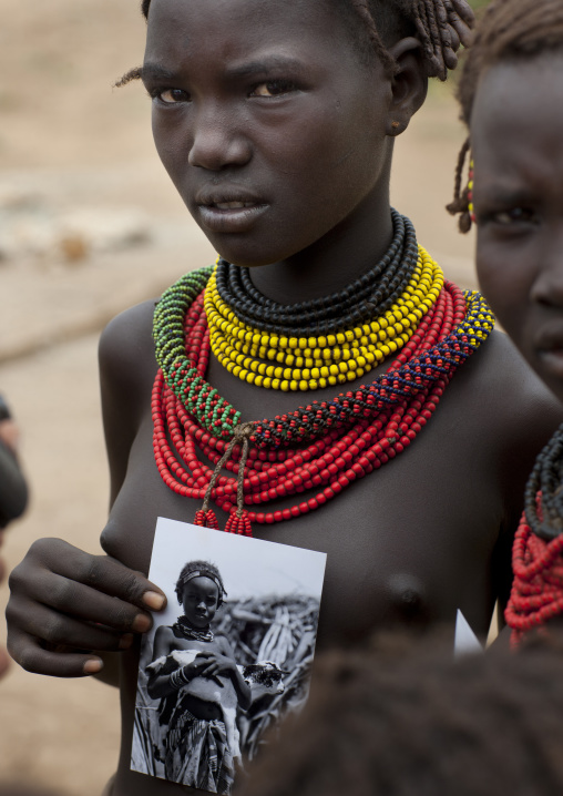 Teenage Dassanech Girl Wearing Beaded Necklaces Showing A Picture Of Herself With Concerned Look Omo Valley Ethiopia