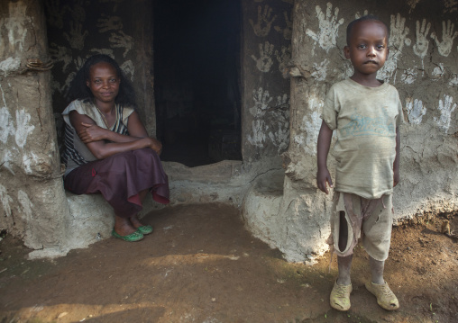 Woman And Her Son In Front Of Their Traditional House Decorated With Handprints To Bring Luck, Tepi, Ethiopia