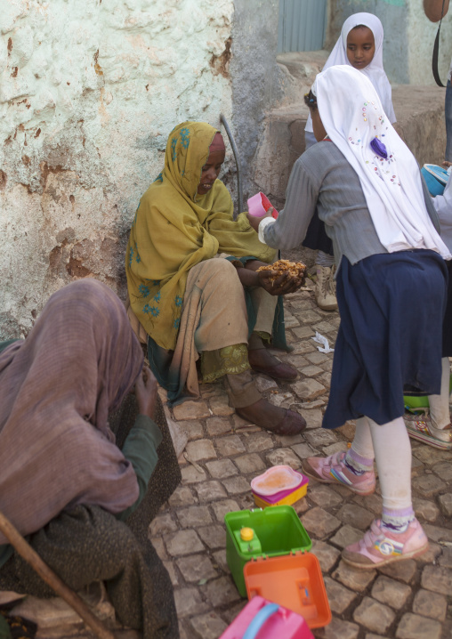 Children Giving Food To A Poor Beggar In The Street, Harar, Ethiopia