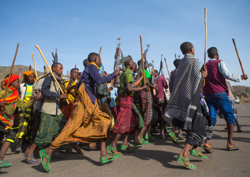 Oromo men with canes and kalashnikovs dancing during a wedding celebration, Oromo, Sambate, Ethiopia