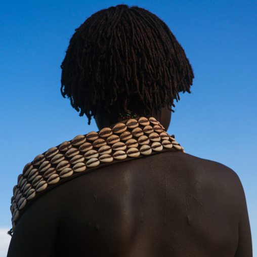 Hamer tribe woman with a shell necklace attending a bull jumping ceremony, Omo valley, Turmi, Ethiopia