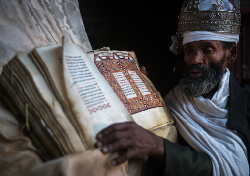Ethiopian orthodox priest with an old bible in nakuto lab rock church, Amhara region, Lalibela, Ethiopia