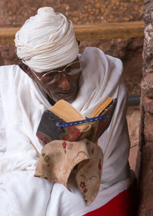 Orthodox priest praying with a bible, Amhara region, Lalibela, Ethiopia