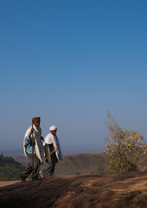 Ethiopian priests walking along a hill, Amhara region, Lalibela, Ethiopia