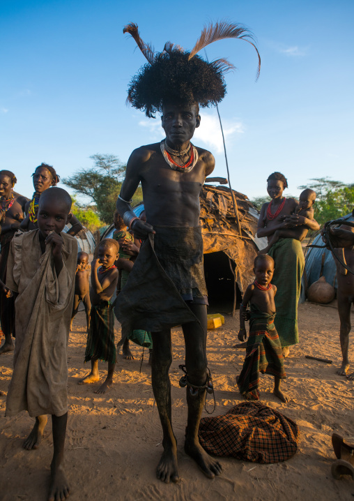 Dassanech men put on leopard skins and ostrich feathers headdresses to join dimi ceremony to celebrate circumcision of teenagers, Omo valley, Omorate, Ethiopia