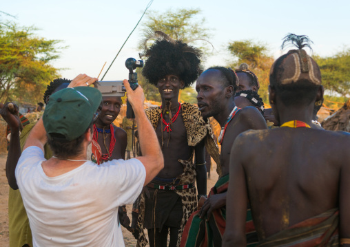 European tourist showing the screen of his camera in dassanech tribe, Omo valley, Omorate, Ethiopia