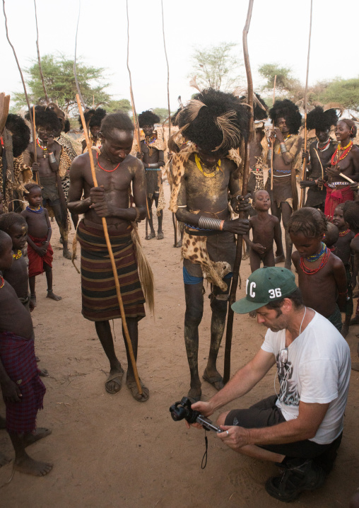 European tourist showing the screen of his camera in dassanech tribe, Omo valley, Omorate, Ethiopia