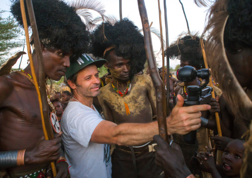 European tourist showing the screen of his camera in dassanech tribe, Omo valley, Omorate, Ethiopia