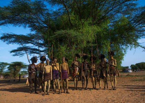 Dassanech men with leopard skins and ostrich feathers headwears during dimi ceremony to celebrate circumcision of teenagers, Omo valley, Omorate, Ethiopia