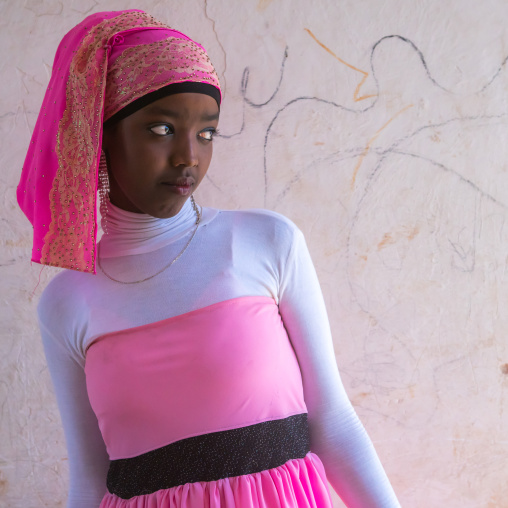 Beautiful teenage girl in pink in the street of the old town, Harari region, Harar, Ethiopia