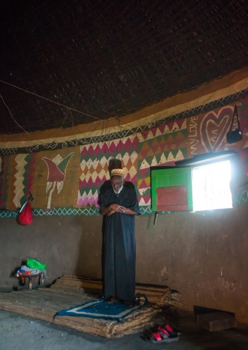 Ethiopia, Kembata, Alaba Kuito, ethiopian muslim man praying inside his traditional painted and decorated house