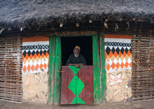 Ethiopia, Kembata, Alaba Kuito, ethiopian muslim man standing in front of his traditional painted house