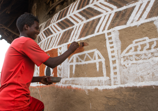 Ethiopia, Kembata, Alaba Kuito, young man painting the wall of a traditional ethiopian house