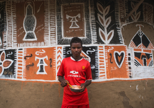 Ethiopia, Kembata, Alaba Kuito, young man painting the wall of a traditional ethiopian house