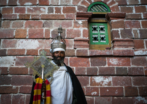 Ethiopian orthodox priest holding a cross inside nakuto lab rock church, Amhara region, Lalibela, Ethiopia