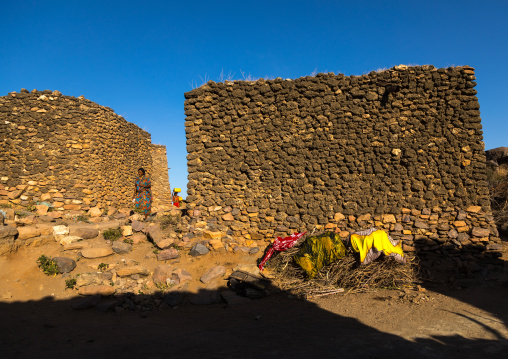 Argoba women carrying water in jericans in a traditional stone houses cliff-top village, Harari Region, Koremi, Ethiopia