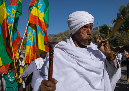 Ethiopian orthodox priest blowing in a horn during the colorful Timkat epiphany festival, Amhara region, Lalibela, Ethiopia