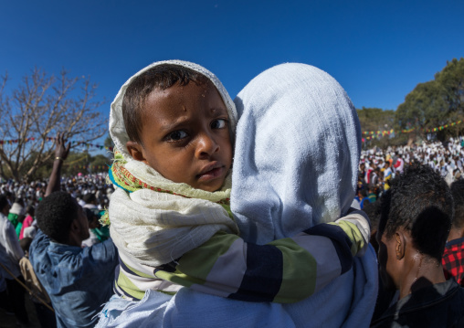 Ethiopian mother holding her wet son after taking the holy bath during Timkat epiphany festival, Amhara region, Lalibela, Ethiopia