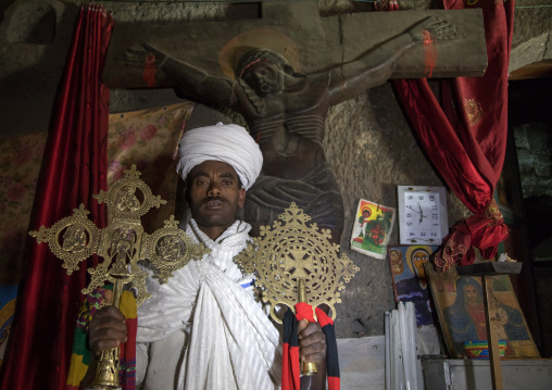 Portrait of an ethiopian orthodox priest holding crosses inside Asheten mariam rock hewn church, Amhara region, Lalibela, Ethiopia