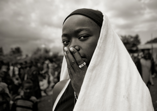 Veiled dizi girl with the hand on her mouth, Tum market, Omo valley, Ethiopia