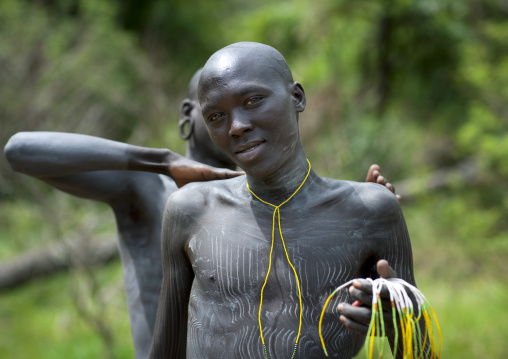 Clay body paintings on Suri warriors before donga stick fighting, Turgit village, Omo valley, Ethiopia