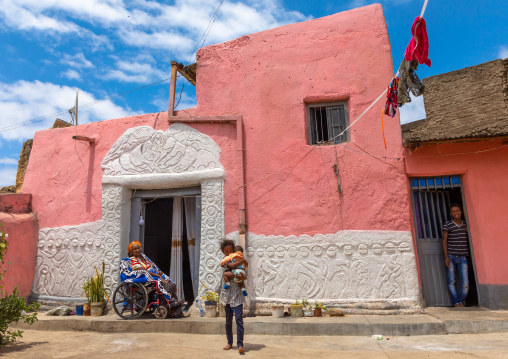 Disabled woman in front of a traditional house in the old town, Harari region, Harar, Ethiopia