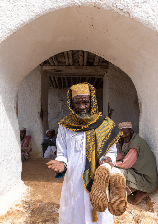 Oromo pilgrim man with his shoes in the hands in Sheikh Hussein shrine, Oromia, Sheik Hussein, Ethiopia