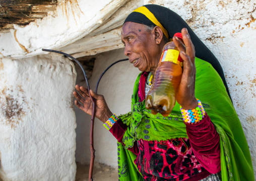 Oromo pilgrim woman with holy water in a bottle in the shrine of the tomb of sufi Sheikh Hussein , Oromia, Sheik Hussein, Ethiopia