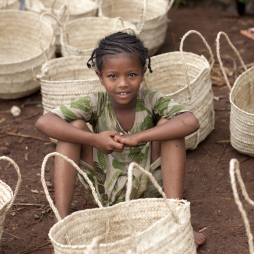 Young girl sitting in the middle of baskets, Ethiopia