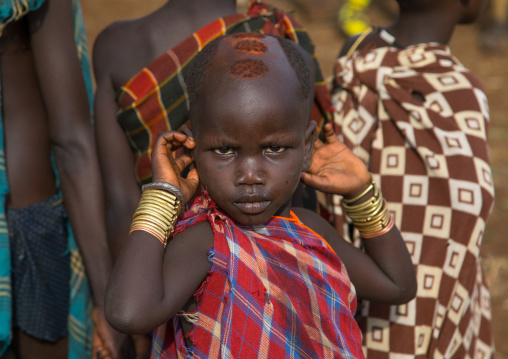 Little girl during the fat men ceremony in Bodi tribe, Omo valley, Hana Mursi, Ethiopia