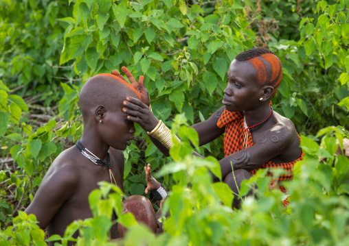 Women makeup during the fat men ceremony in Bodi tribe, Omo valley, Hana Mursi, Ethiopia