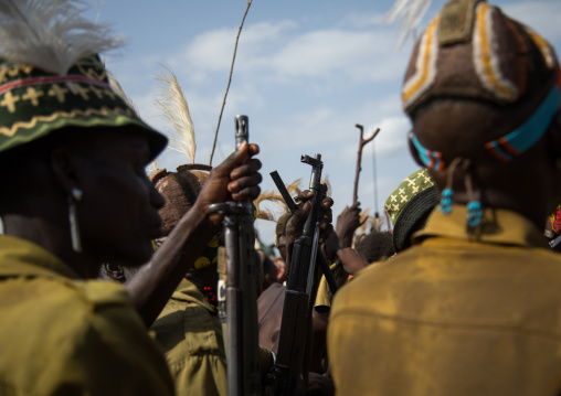 Tribe warriors during the proud ox ceremony in the Dassanech tribe waiting to share the cow meat, Turkana County, Omorate, Ethiopia