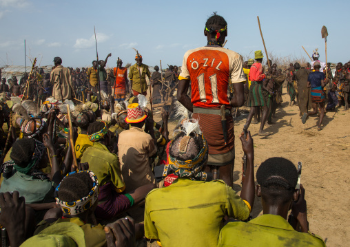 Tribe warriors during the proud ox ceremony in the Dassanech tribe waiting to share the cow meat, Turkana County, Omorate, Ethiopia