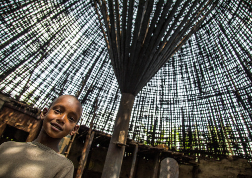 Boy under a Gurage traditional roof without thatch in renovation, Gurage Zone, Butajira, Ethiopia
