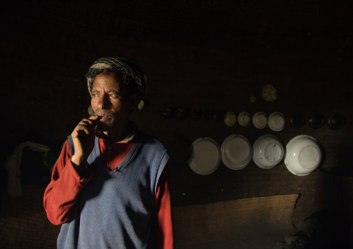 Portrait of a Gurage tribe man inside his house decorated with plates on the walls, Gurage Zone, Butajira, Ethiopia