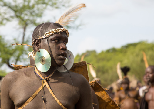 Bodi tribe fat man with a dvd as earrings during Kael ceremony, Omo valley, Hana Mursi, Ethiopia