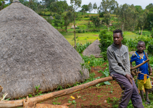 Boys sit near their traditional house, Gamo Gofa Zone, Ganta, Ethiopia