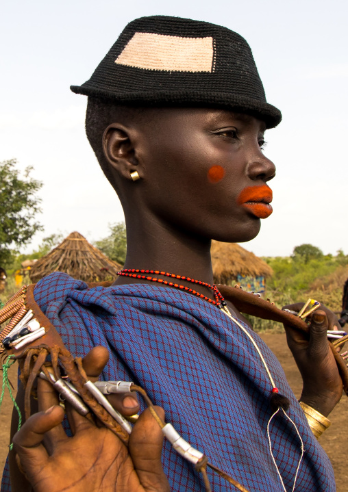 Beautiful young woman with a hat and some make up during the fat men ceremony in the Bodi tribe, Omo valley, Hana Mursi, Ethiopia