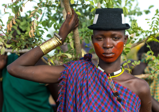 Beautiful young woman with a hat and some make up during the fat men ceremony in the Bodi tribe, Omo valley, Hana Mursi, Ethiopia